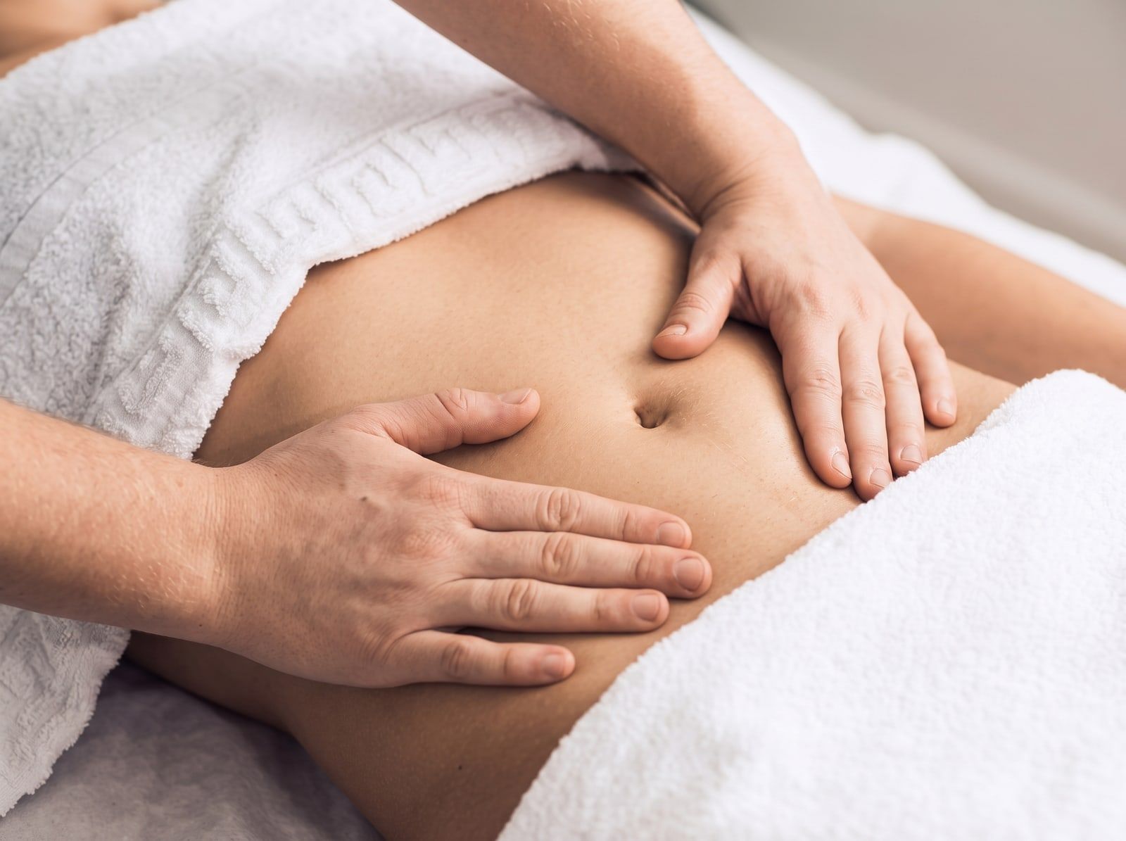 Hands giving a gentle postnatal tummy massage